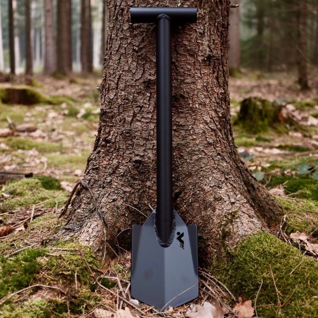 Black DOT shovel standing in front of a tree in the forest