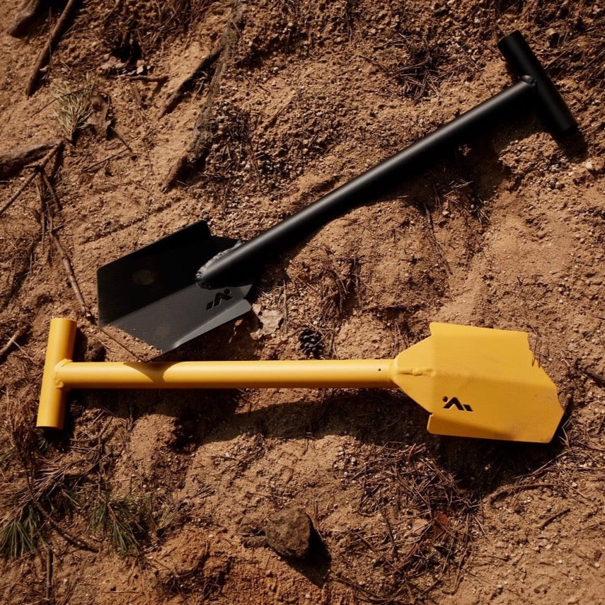 Black and yellow DOT shovel laying in the sand