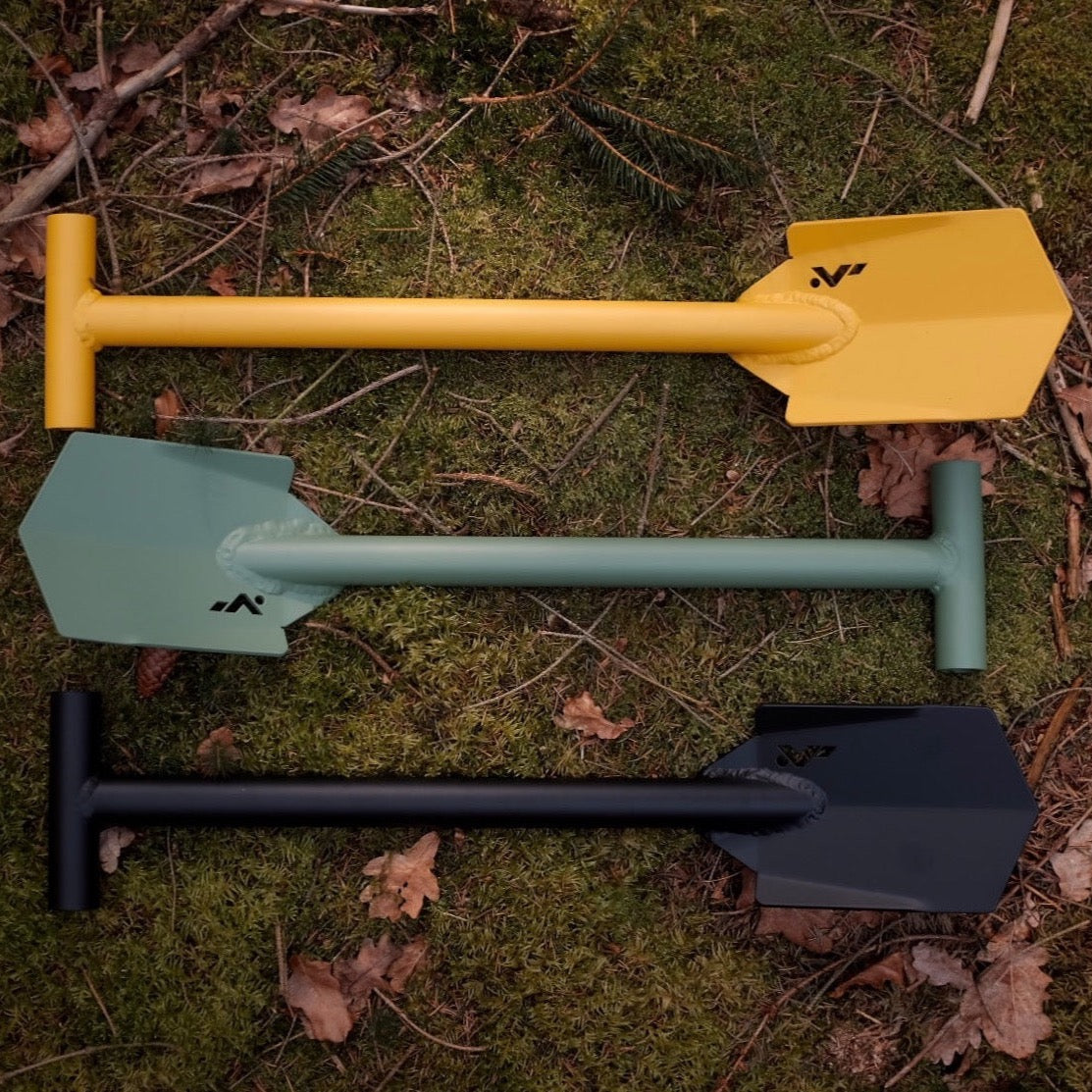 Yellow green and black DOT shovel laying on moss