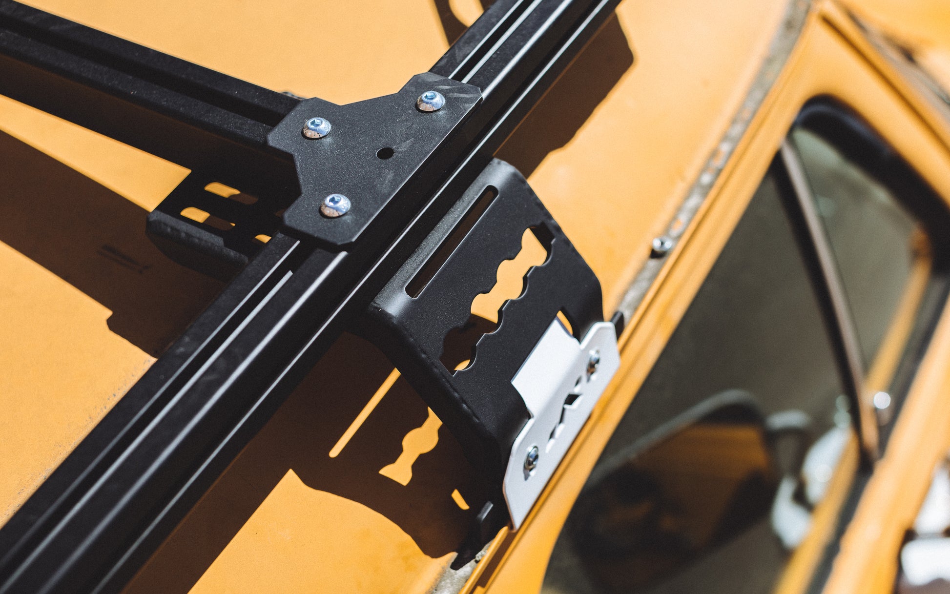 Roof rack mount and T-Bracket mounted on a yellow GMC van